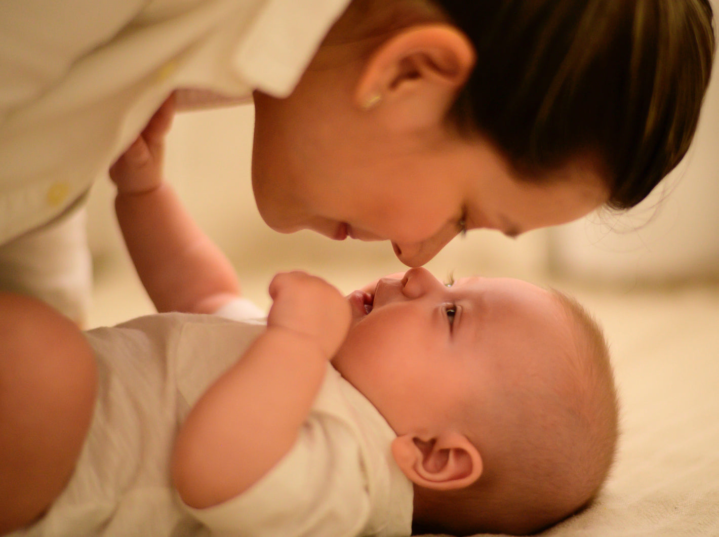 Mother and baby looking at each other face to face and touching noses